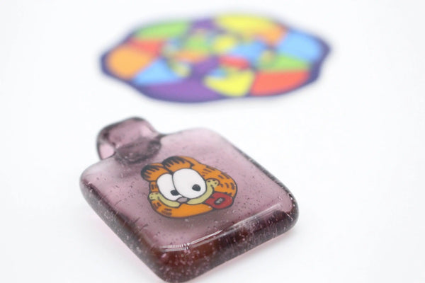 East Atlanta S&V Garfield flip pendant from ItsKindOfAKushyStory featuring a playful cartoon cat design.